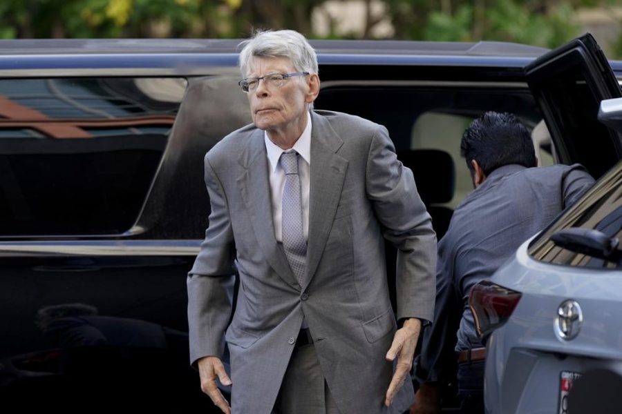 Stephen King walks toward the courthouse, out of frame