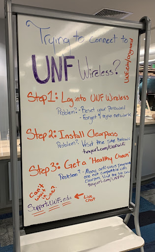 A whiteboard reads "Trying to connect to UNF Wireless?" with three steps for how to download ClearPass OnGuard