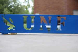Outline of the UNF logo as the net for a ping pong table