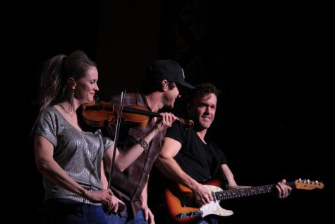 Three artists perform on stage