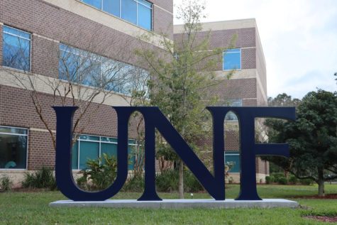 A large, blue statue with the letters UNF on a concrete slab