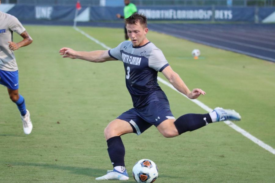 Player kicks the ball out of the corner of the field.