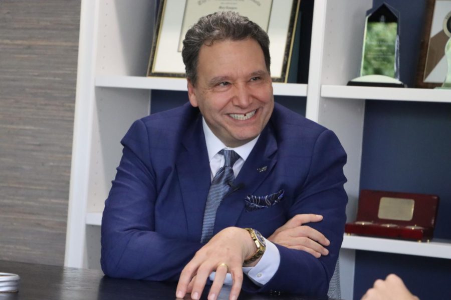 Limayem smiling, wearing a blue suit
