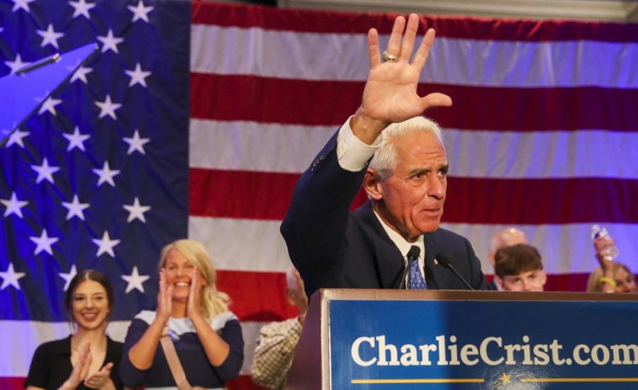 Charile Crist waves while on a podium