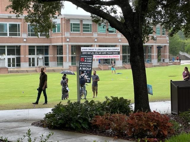 preachers on the green hold large banners