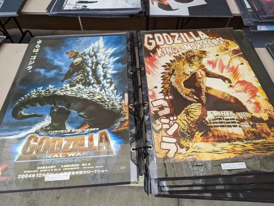 Two laminated large posters of Godzilla on a table