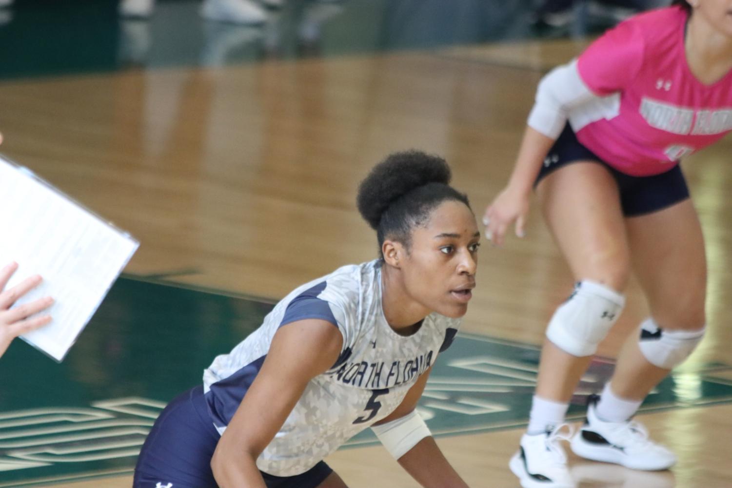 Volleyball player stands awaiting next play.