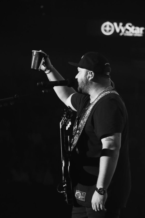 Mitchell Tenpenny raises a cup, black and white photo