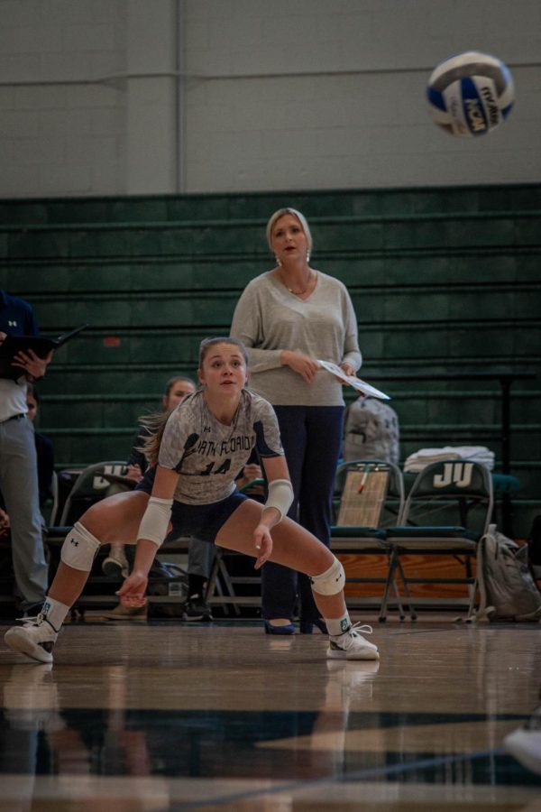 Volleyball player with head coach looking on from behind