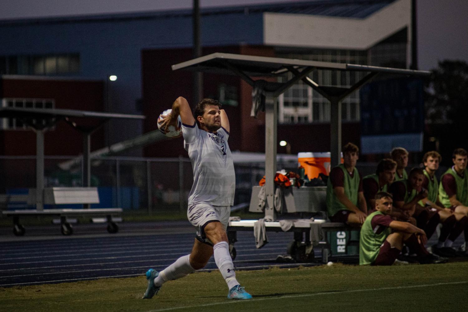 Soccer player throws the ball into play