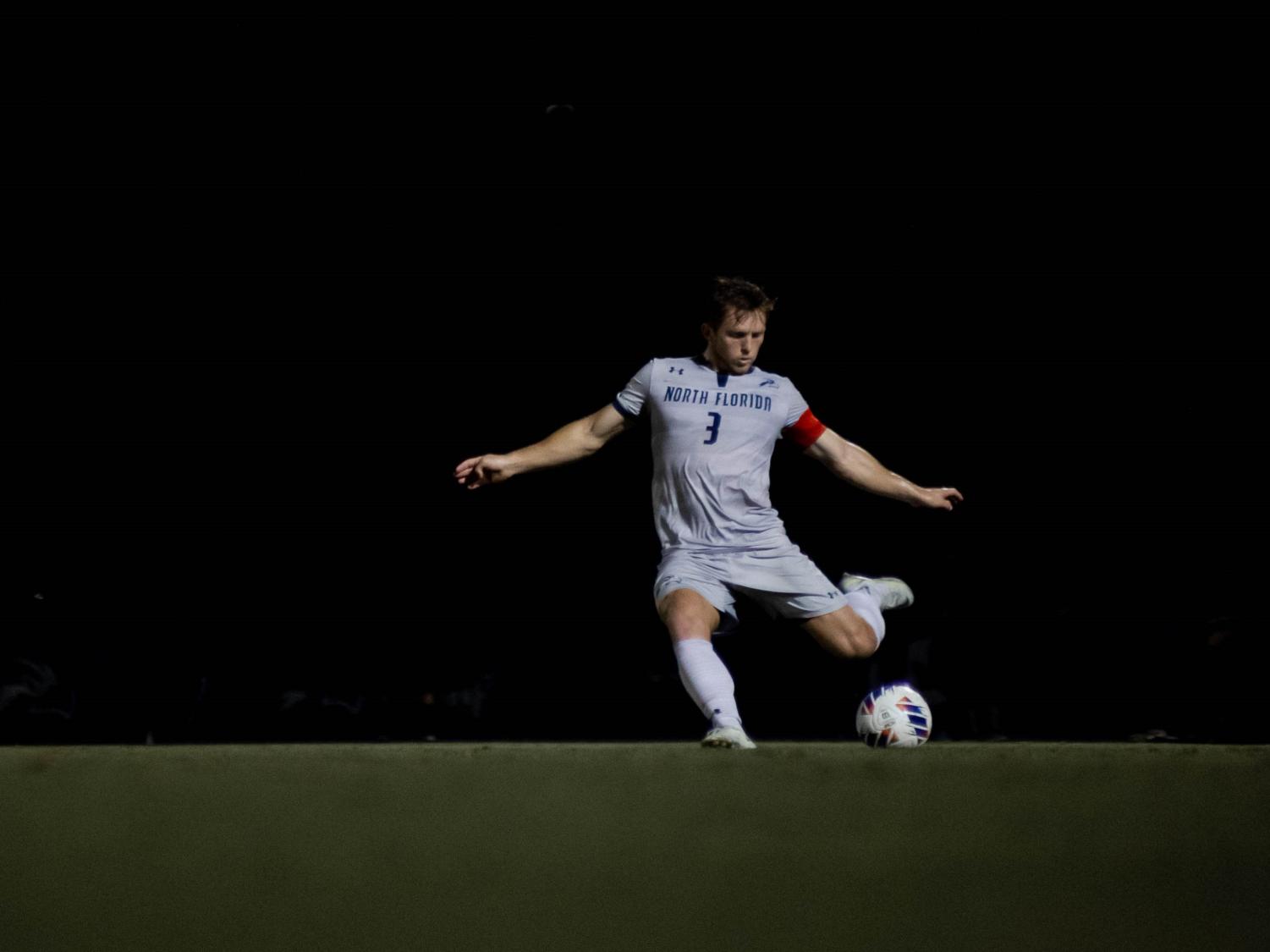 Soccer player prepares to kick ball