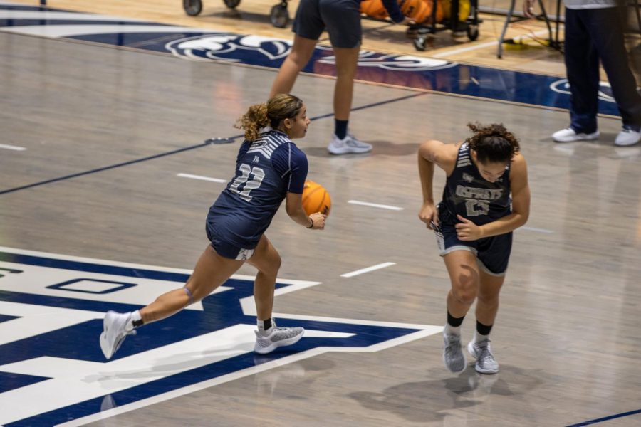 Women's basketball player dribbles the ball.