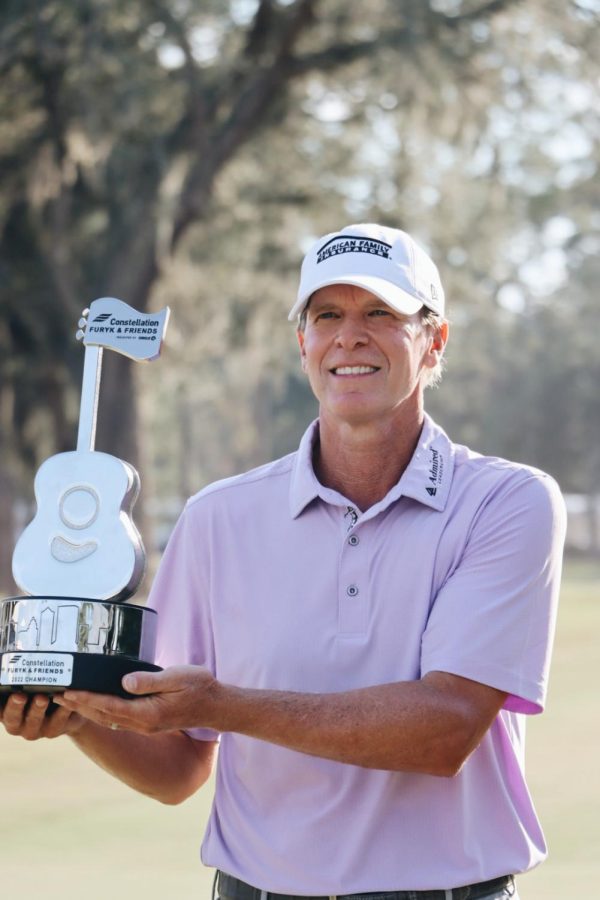 Golfer holds a trophy