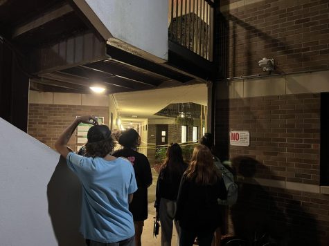 Students stand behind yellow caution tape