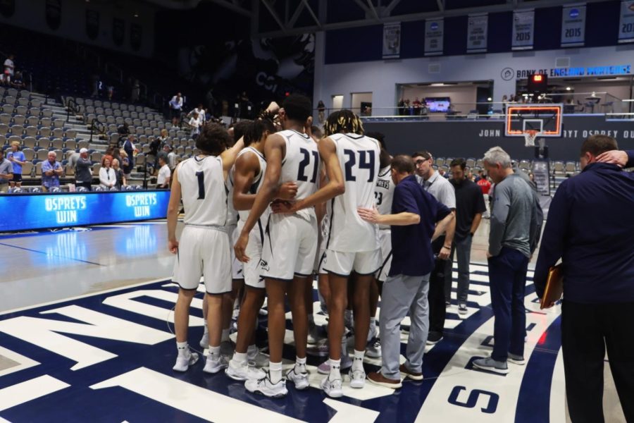 Men's basketball players huddle during a game