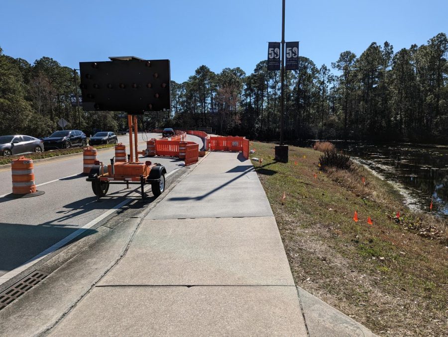 Orange cones and digital screen blocking off right lane on street