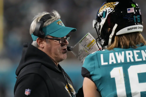 Jacksonville Jaguars head coach Doug Pederson, left, speaks to Jacksonville Jaguars quarterback Trevor Lawrence (16) on the sidelines during the first half of an NFL wild-card football game against the Los Angeles Chargers, Saturday, Jan. 14, 2023, in Jacksonville, Fla. (AP Photo/Chris OMeara)