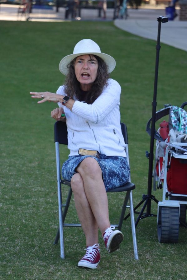 Sister Cindy sitting down wearing a white hate, white long sleeve shirt and blue skirt