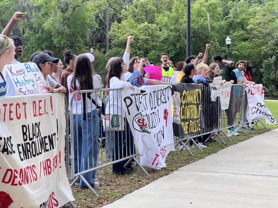 Yelling chants and raising their fists in the air, protesters stand against metal barriers on FAMU's campus Tuesday afternoon. 