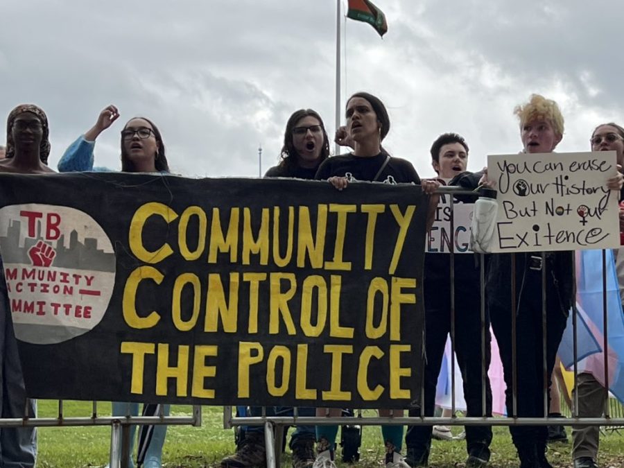 Yelling chants and raising their fists in the air, protesters stand against metal barriers on FAMU's campus Tuesday afternoon. 