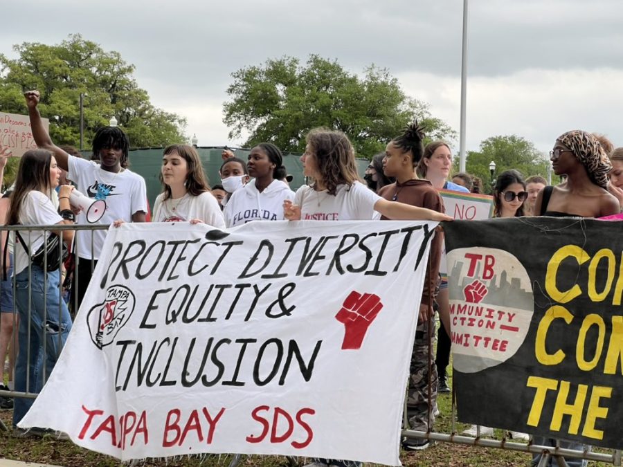 Yelling chants and raising their fists in the air, protesters stand against metal barriers on FAMU's campus Tuesday afternoon. 