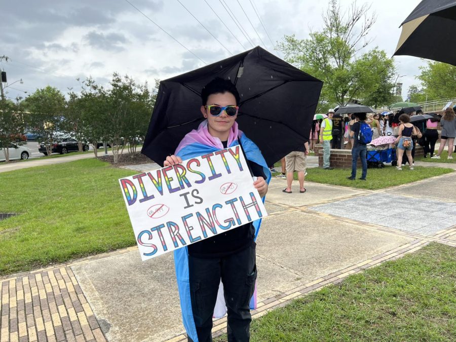 Ashton Bush, a University of North Florida junior and sociology major, holds up a sign with the words "Diversity is Strength" written on it. 