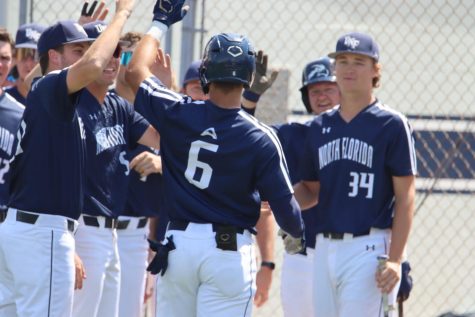 UNF baseball players high-five each other