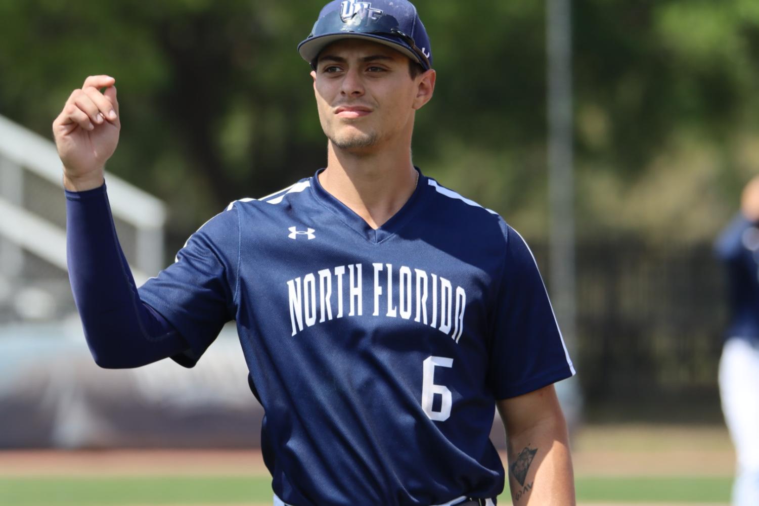 Baseball player standing with hand in the air