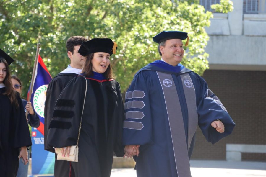 UNF President Moez Limayem (right) holds hands with his wife, Dr. Alya Limayem (left) as they make their way across the campus to Lazzara Hall for his inauguration ceremony. 