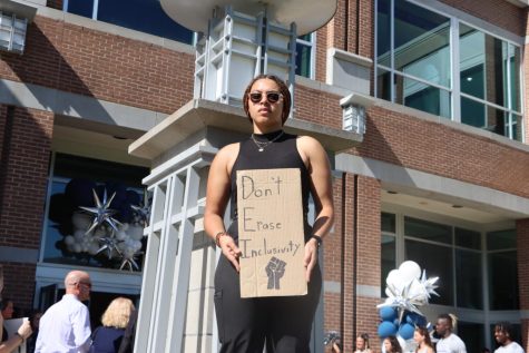 Lissie Morales, the president of Students for a Democratic Society, holds a homemade sign in front of Lazzara Hall where University of North Florida President Moez Limayem would later be inaugurated. 