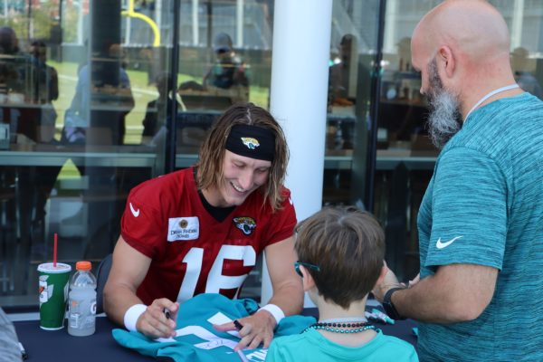 Lawrence signs autograph for child