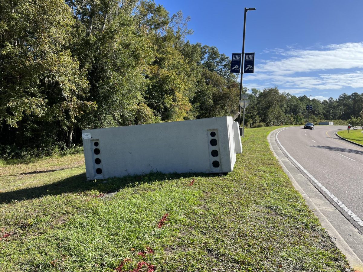 A 6’x12’ manhole top, according to the JEA label, sits in a grassy area alongside UNF Drive. (Carter Mudgett/Spinnaker)
