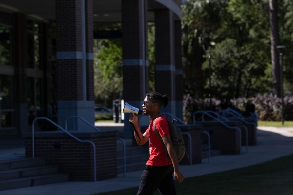 Marlo Crosby, vice president of UNF SDS, chants into a megaphone as they walk across the Green during a student walkout in support of Palestine on Wednesday, Oct. 25, 2023. 