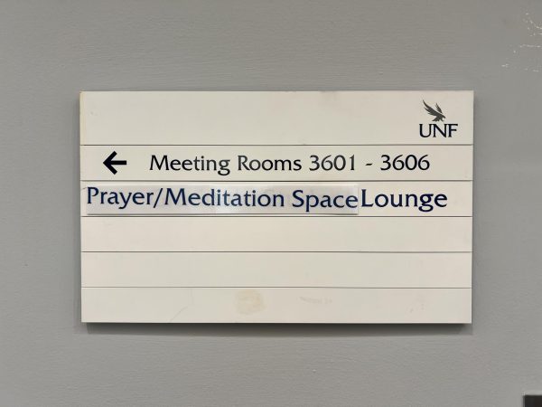 A sign on the third floor of the Student Union West building points toward the newly renamed Interfaith Space.