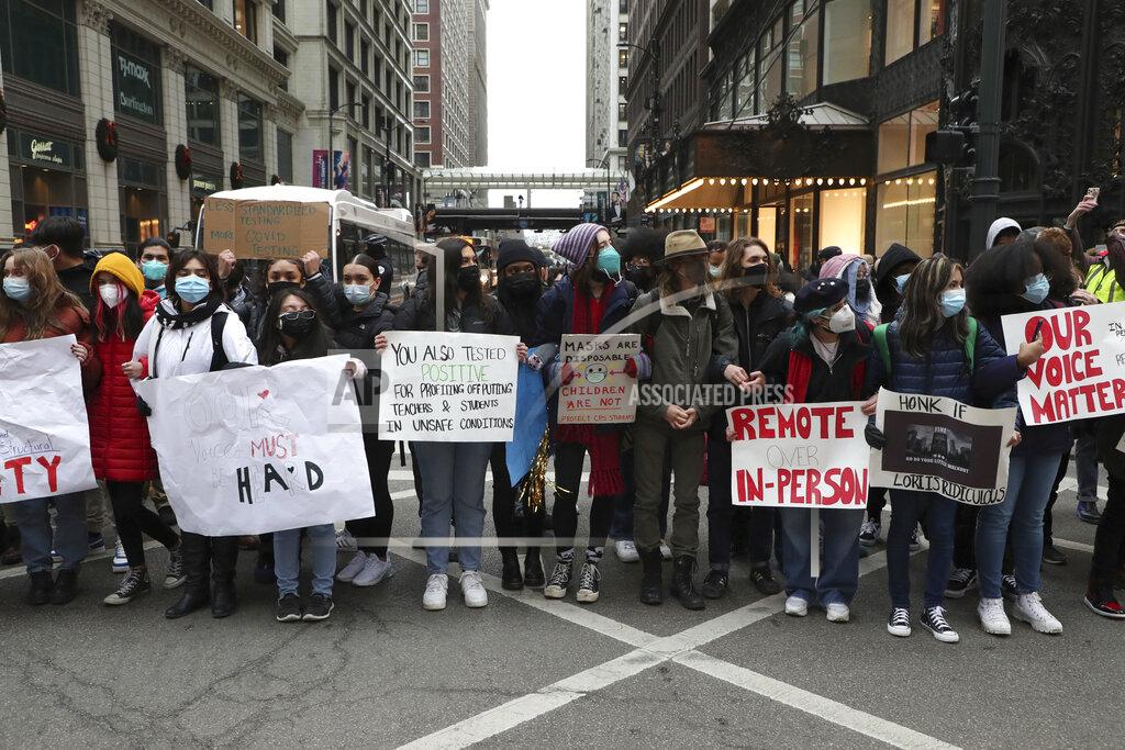Protesters calling for better COVID-19 health and safety procedures in Chicago public schools briefly block traffic at State Street and Madison Street in Chicago near Chicago Public Schools headquarters on Friday, Jan. 14, 2022. (Terrence Antonio James/Chicago Tribune)