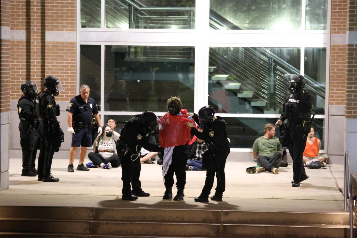 Officers pat down a protester.