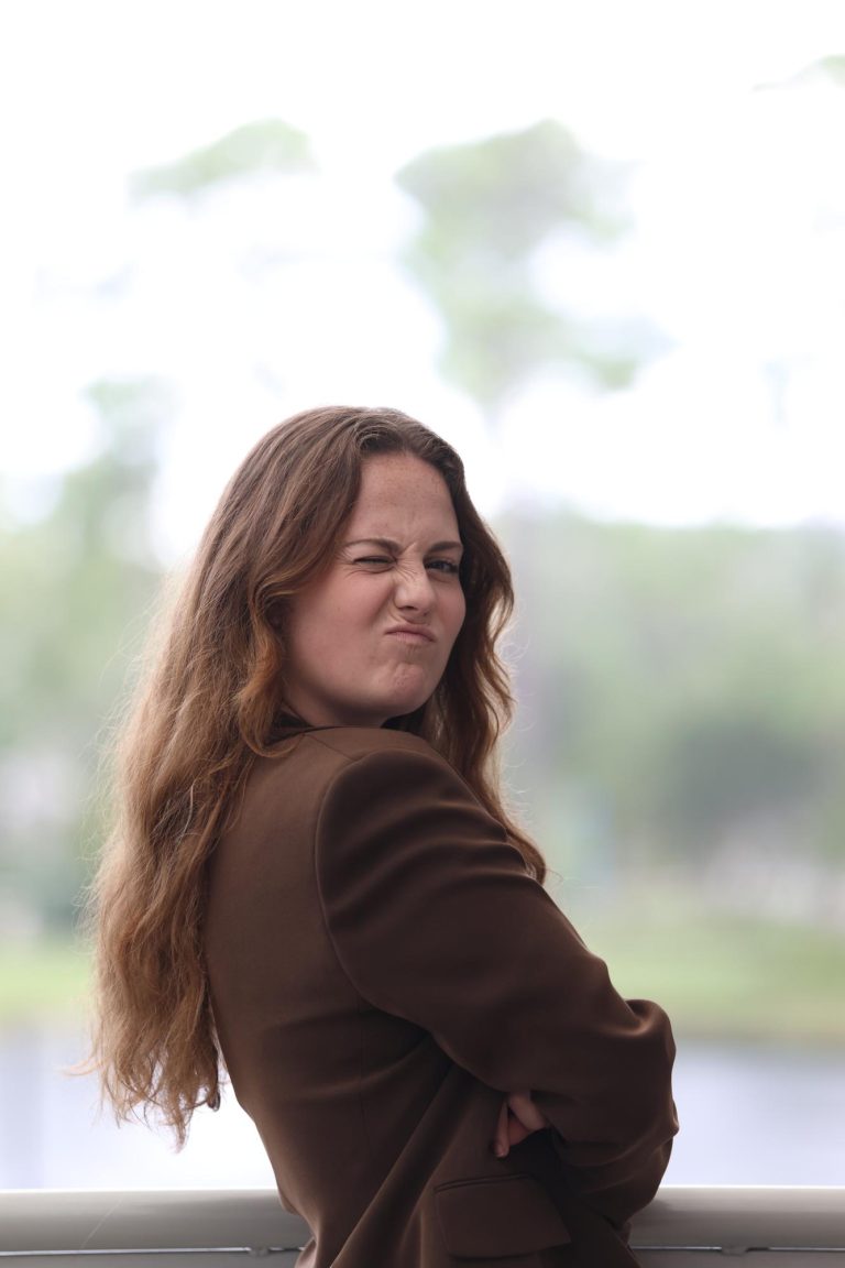 young woman in stylish brown blazer strikes a pose