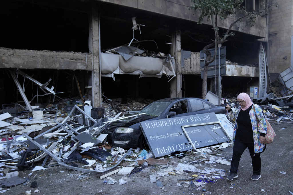 A woman uses her phone to record destroyed shops that were hit Sunday evening in an Israeli airstrike in central Beirut, Lebanon, Monday, Nov. 18, 2024. 