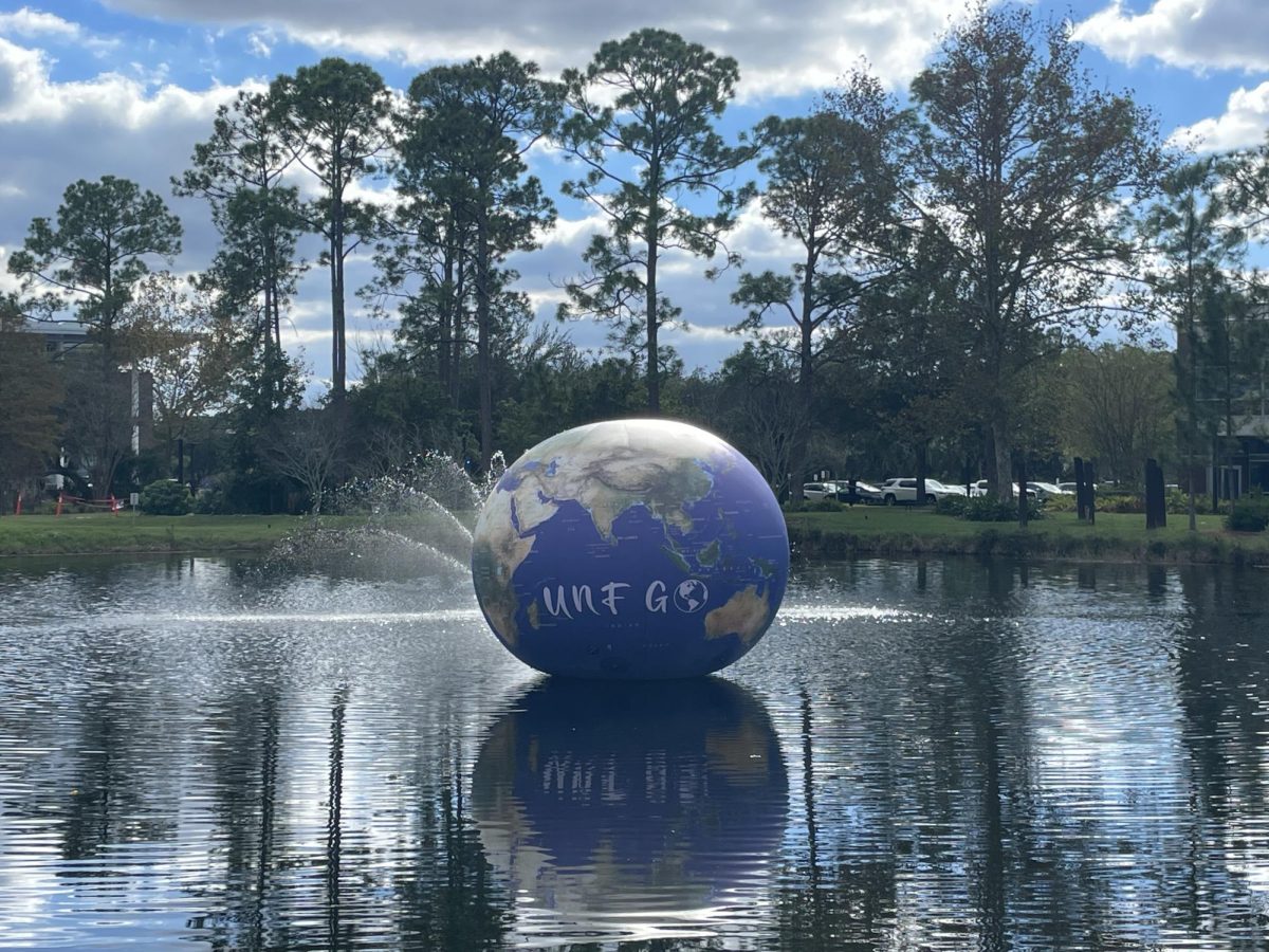 A globe floats in the lake in front of the UNF student union for International Education Week 2024.