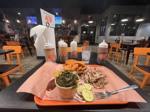 Orders of pulled pork, sweet potato waffle fries and collard greens at The Bearded Pig’s Jax Beach location.