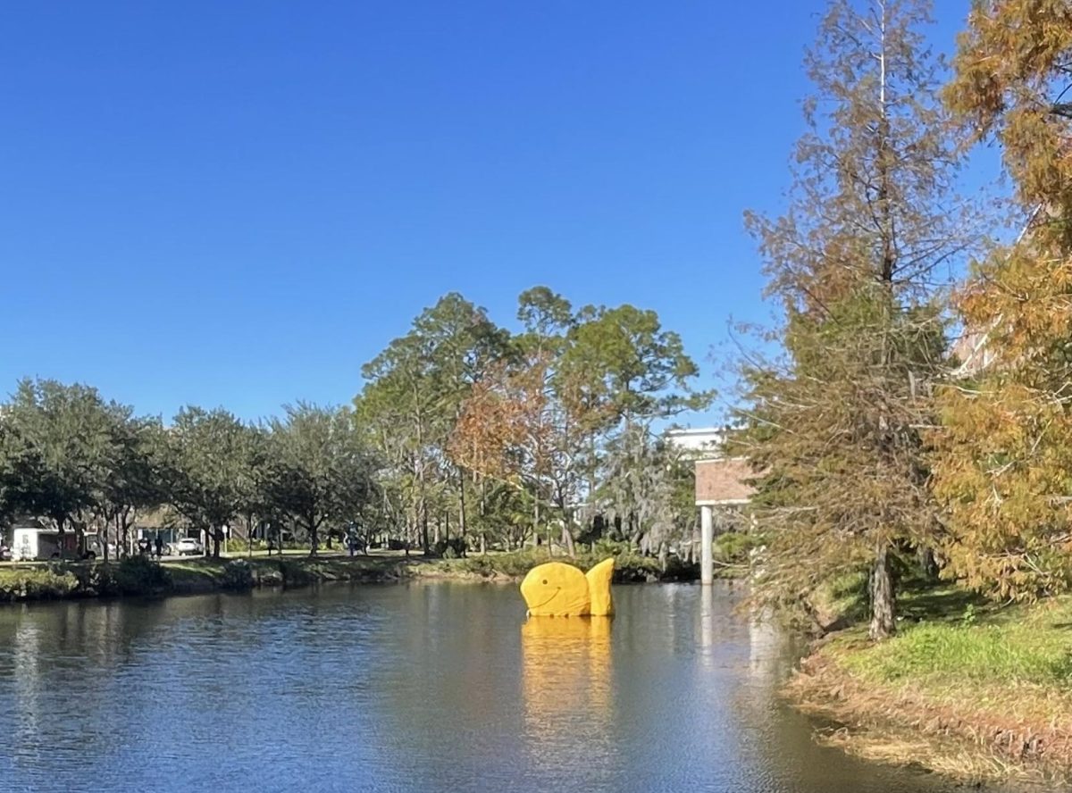 "Goldy," a goldfish sculpture, floats in the lake outside the Thomas G. Carpenter Library and Coggin College of Business at UNF.