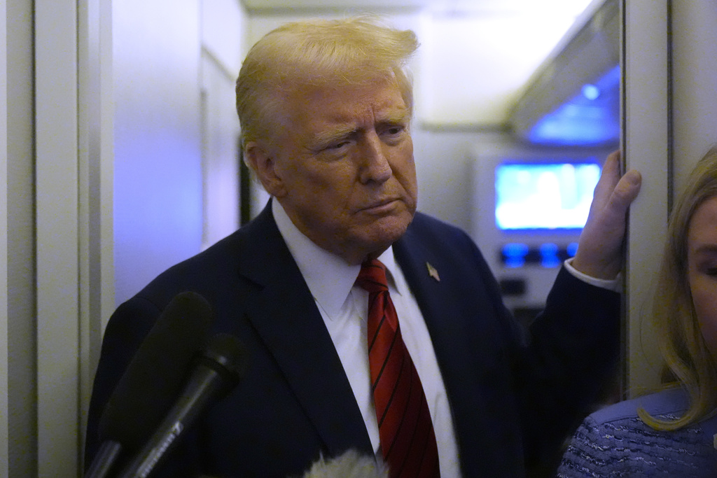 President Donald Trump speaks to reporters aboard Air Force One en route from Miami to Joint Base Andrews, Md., Monday, Jan. 27, 2025. (AP Photo/Mark Schiefelbein)