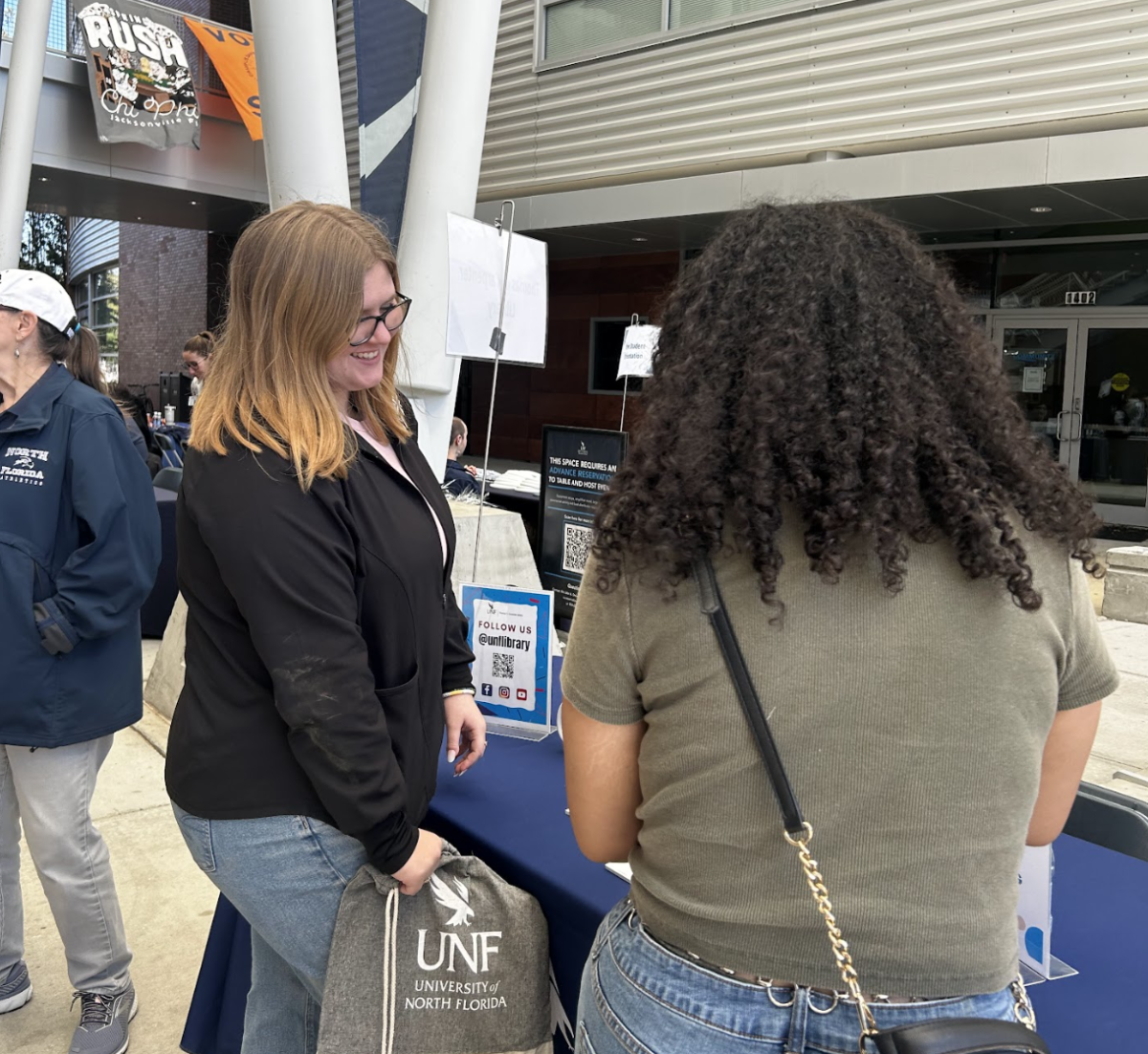 Samantha Altland and Kierra Johnson look at a booth at the UNF Admitted Ospreys Day Resource Fair.