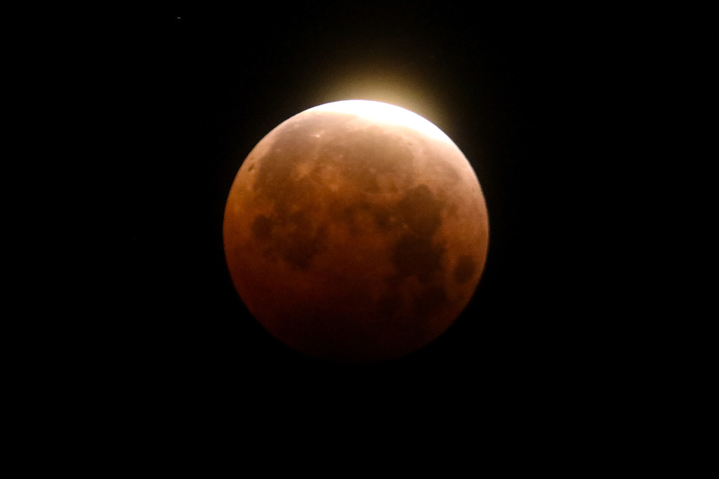 FILE - Light shines from a total lunar eclipse over Santa Monica Beach in Santa Monica, Calif., Wednesday, May 26, 2021. (AP Photo/Ringo H.W. Chiu, File)