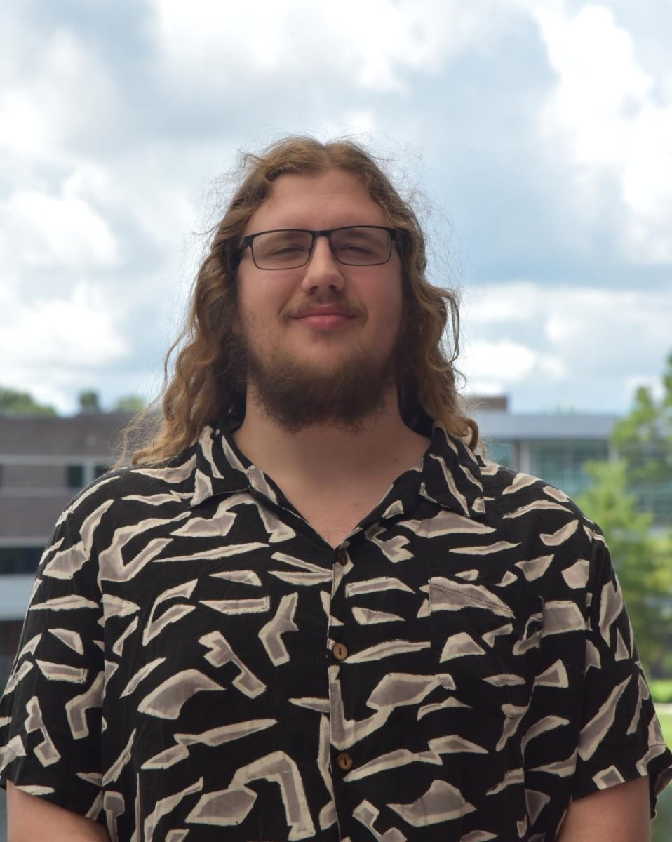 Jack is smiling wearing a black and white button-down shirt
