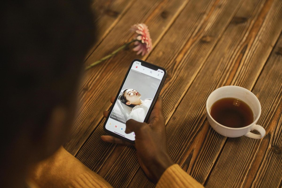 A person photographed scrolling through Tinder.