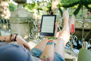 Woman reading on a Kobo, a type of e-reader.