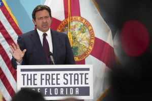 Florida Gov. Ron DeSantis speaks during a public event at a podium that reads "The Free State of Florida" on the front.