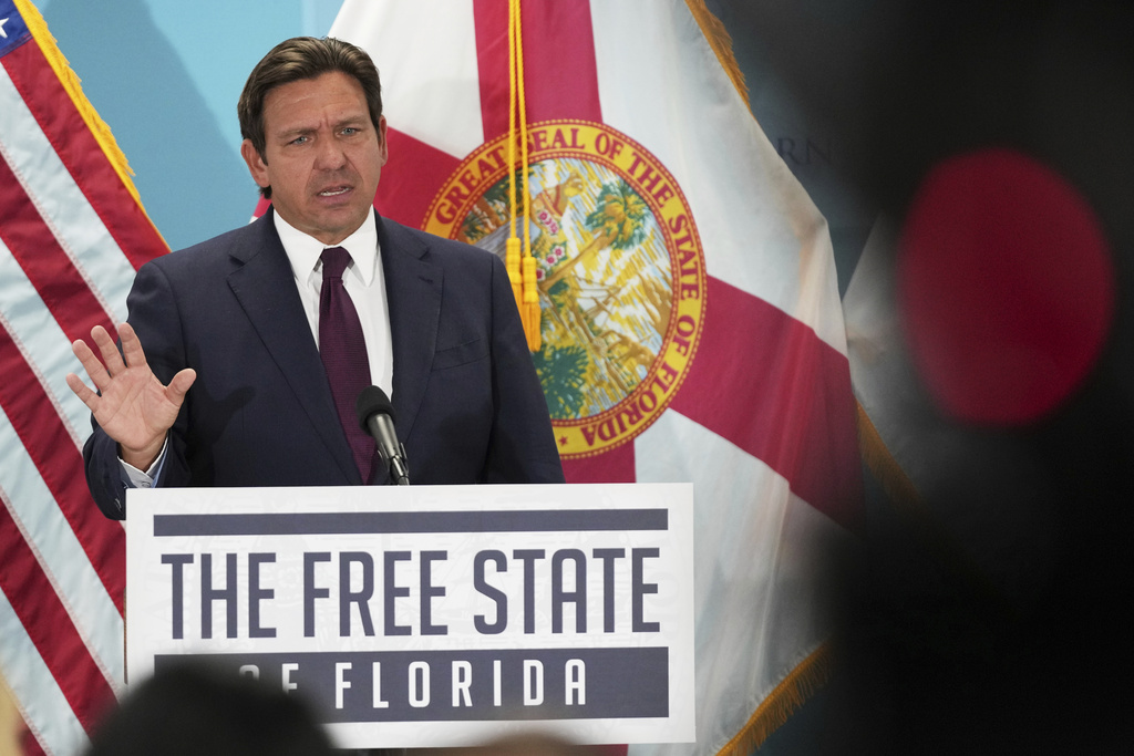 Florida Gov. Ron DeSantis speaks during a public event at a podium that reads "The Free State of Florida" on the front.