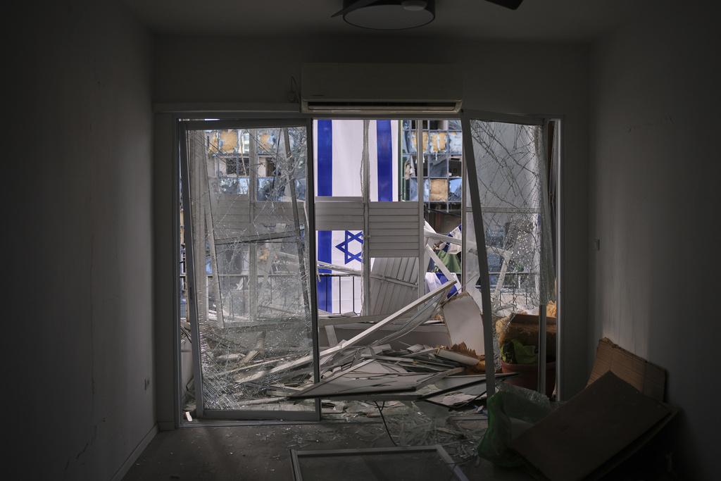 An Israeli flag is hung outside a damaged apartment two days after it was struck by a missile launched from Iran, in Ramat Gan, Israel, on Saturday, June 21, 2025. (AP Photo/Ohad Zwigenberg)